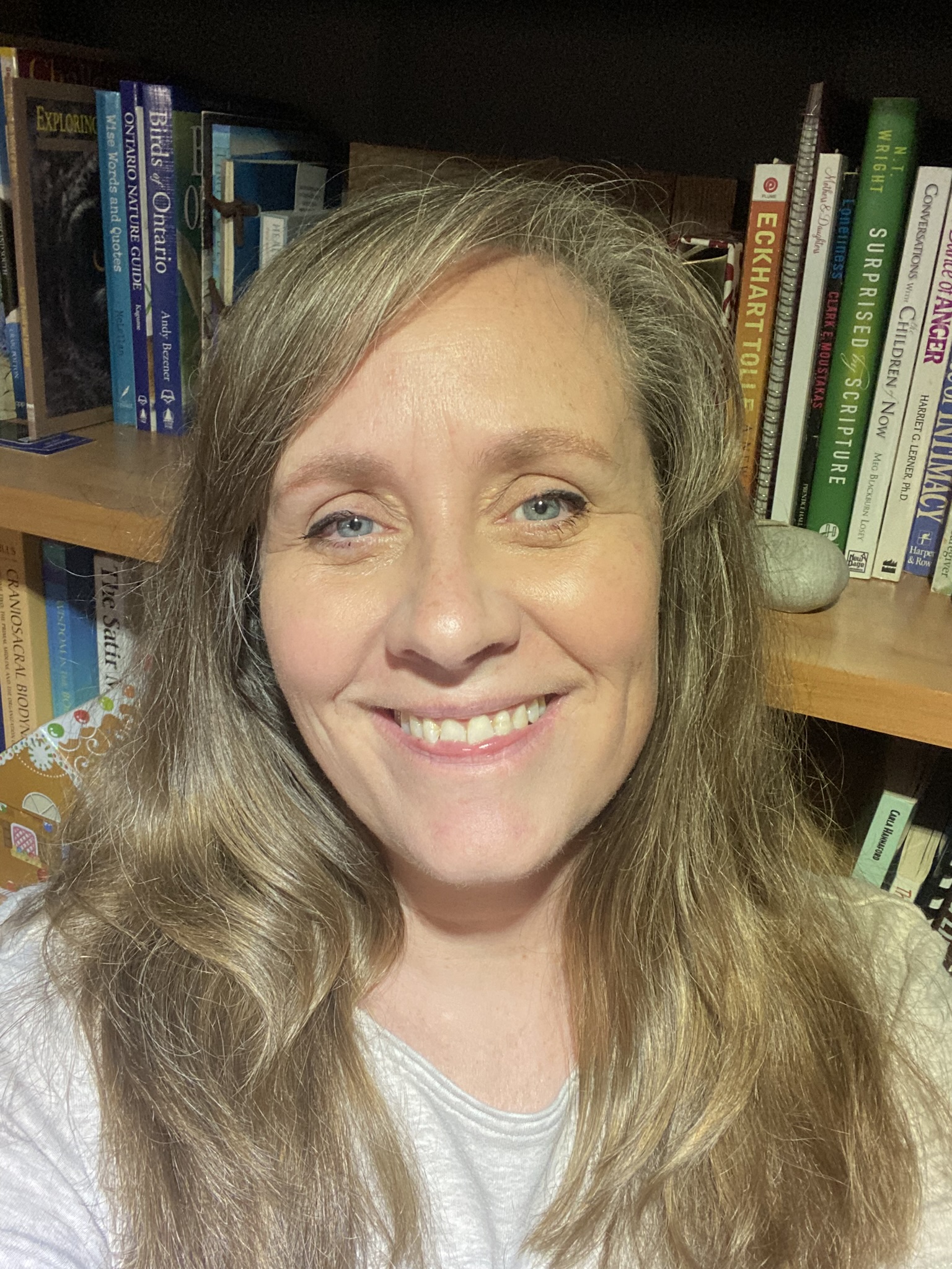 Photo of Shanan Cunnington - a blonde woman with long hair wearing a blue shirt in front of a brick wall
